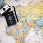 Travel: Camera and passport over a world map
