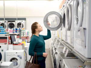 Beautiful woman comparing laundry appliances