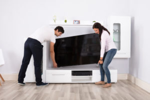 Couple Carrying Flat Television Screen