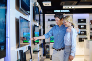 A couple selecting a new television to buy