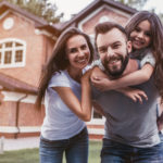 Happy insured family and a house with home insurance
