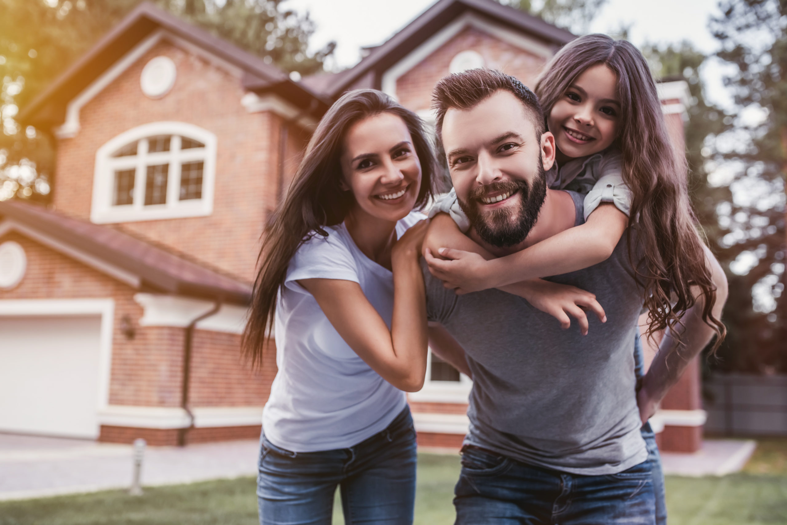 Happy insured family and a house with home insurance