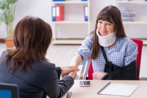 Injured lady visiting lawyer for advice on insurance