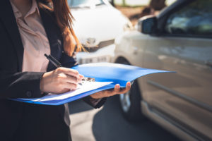 Woman notify insurance agents is writing an accident car crash