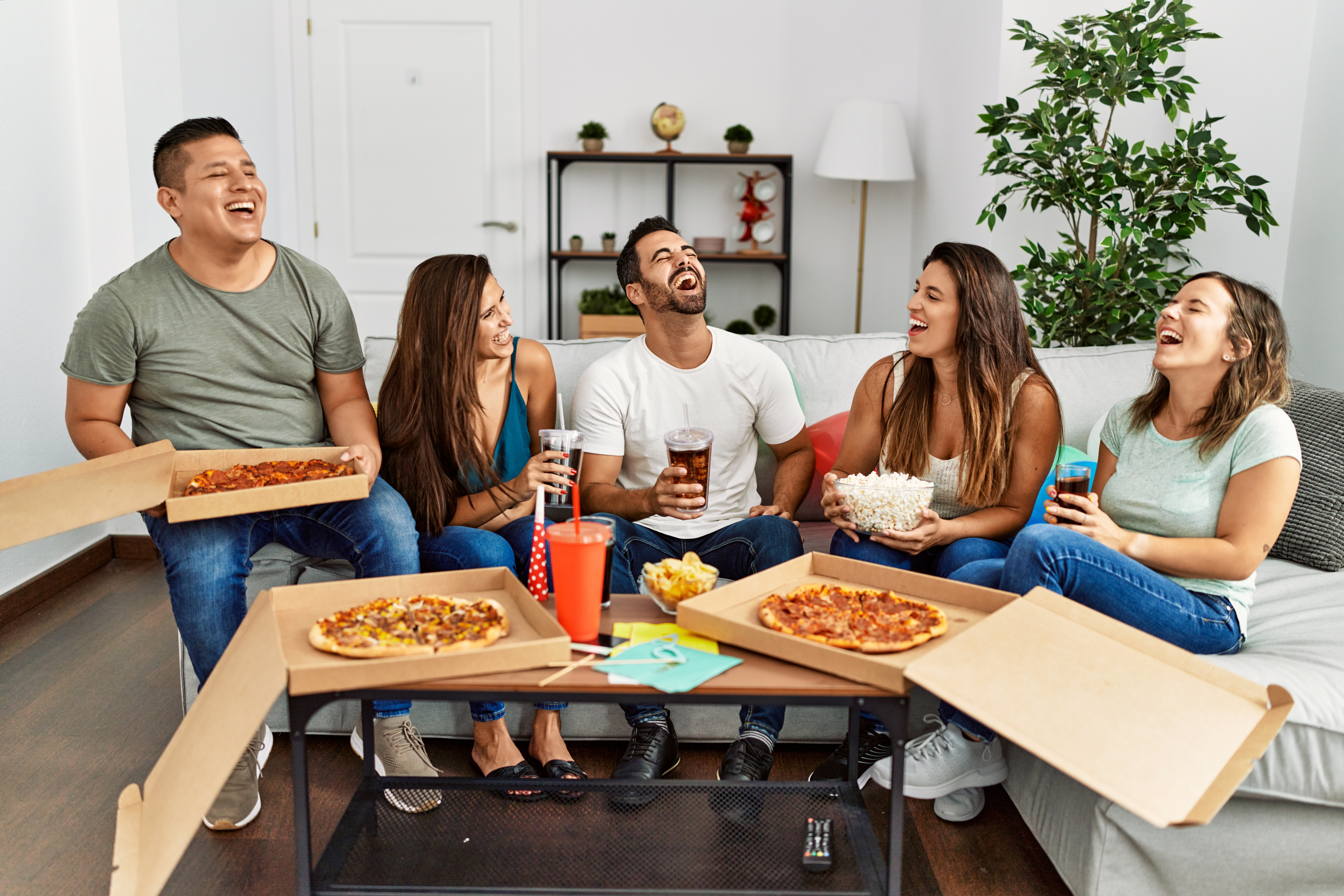 Friends eating a pizza delivered at home