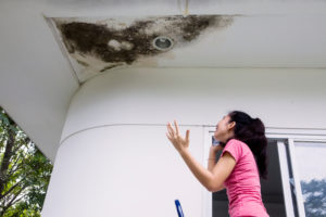 A woman stressed about a damaged ceiling