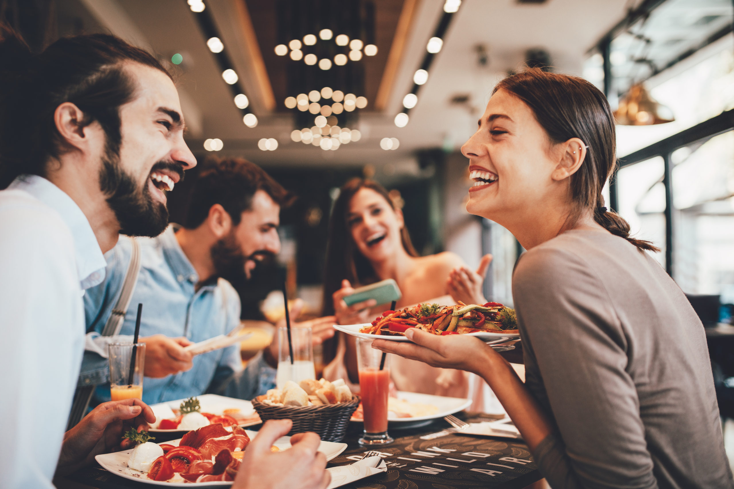 Group of Happy friends eating out at a restaurant