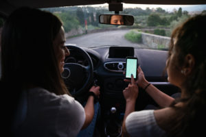 Two young woman using GPS in a rental car