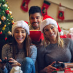 Friends having fun gaming at home during Christmas holidays