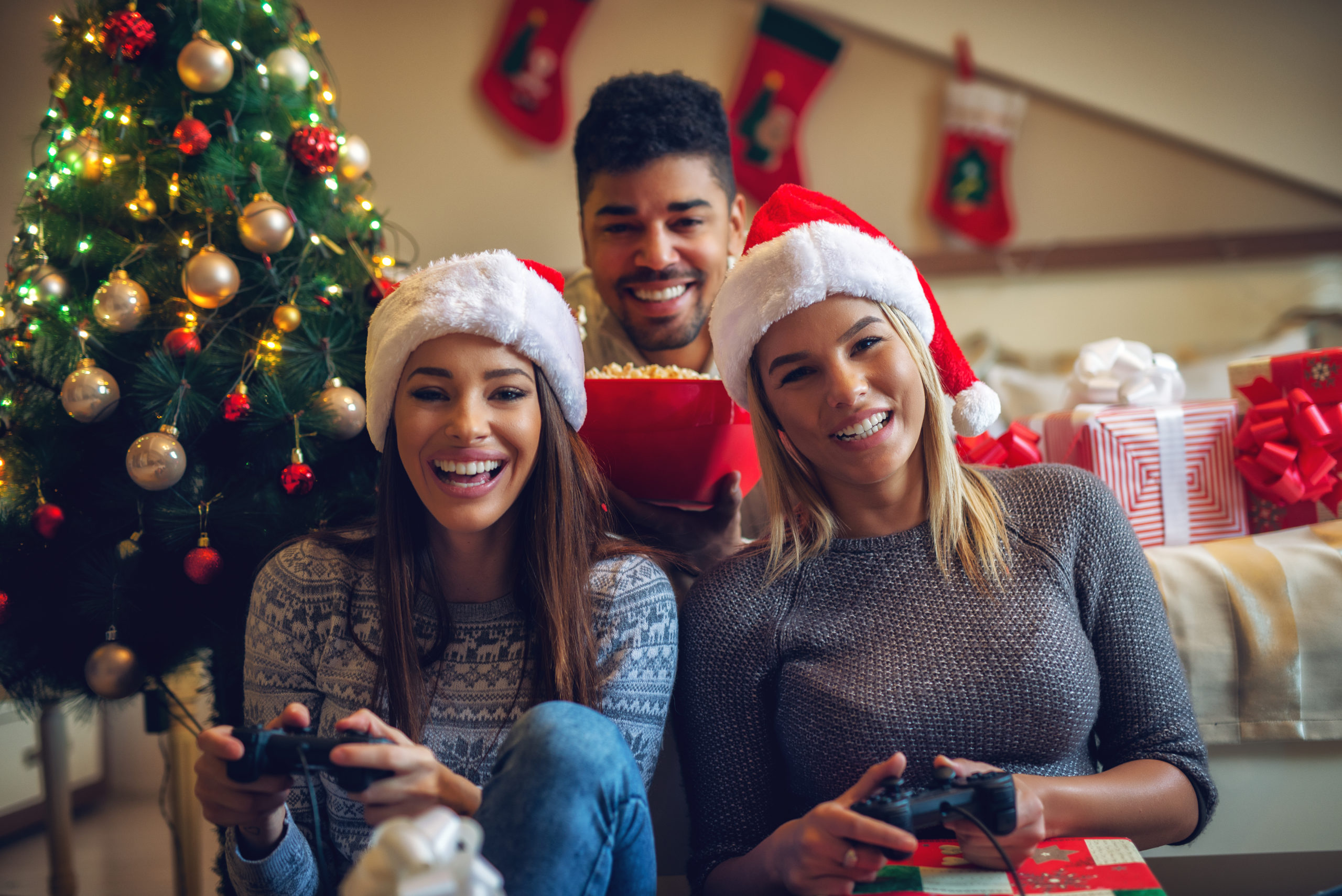 Friends having fun gaming at home during Christmas holidays