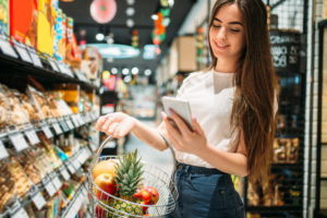 A woman grocery shopping alone to stick to her list