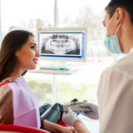 A woman discussing dental implants with her dentist