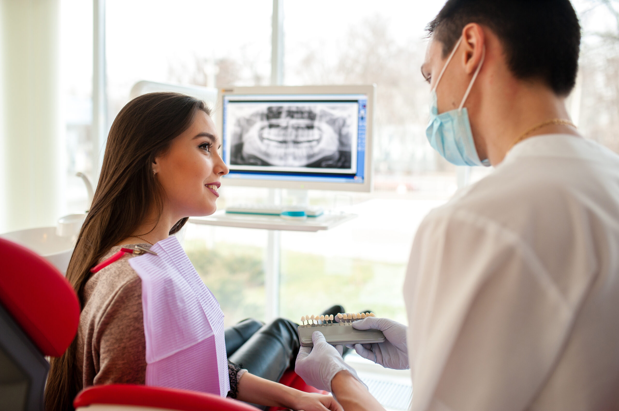 A woman discussing dental implants with her dentist