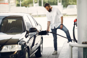 A man at a petrol station using the fuel card from his car lease provider 