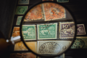 A collector looking at stamp collection to spot clever fakes