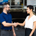 Mechanic shaking hands with satisfied customer after resolving a car complaint