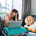 A woman feeling concerned about online booking scams while planning her summer vacation travel.