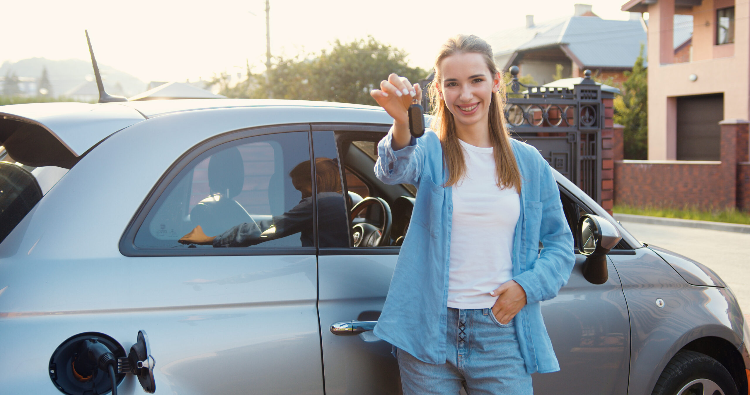Happy woman showing keys to her new fuel efficient car
