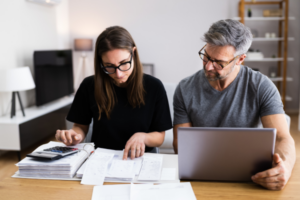 A couple organising their finances and reviewing debt information.