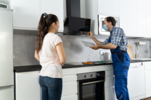 Repairman checking if rangehood is out of warranty