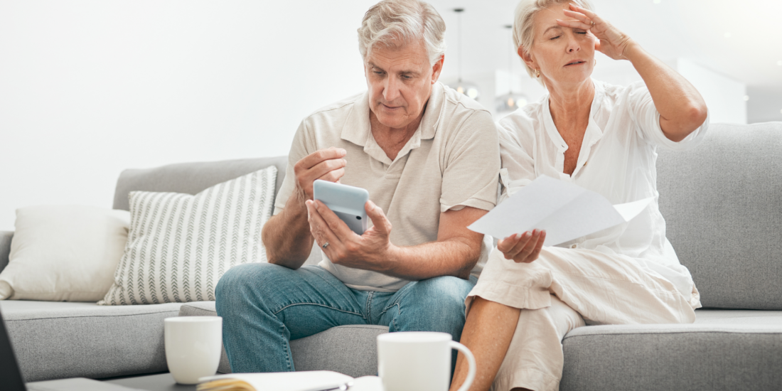 A disappointed couple looking at paperwork after their insurance claim was rejected