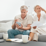 A disappointed couple looking at paperwork after their insurance claim was rejected