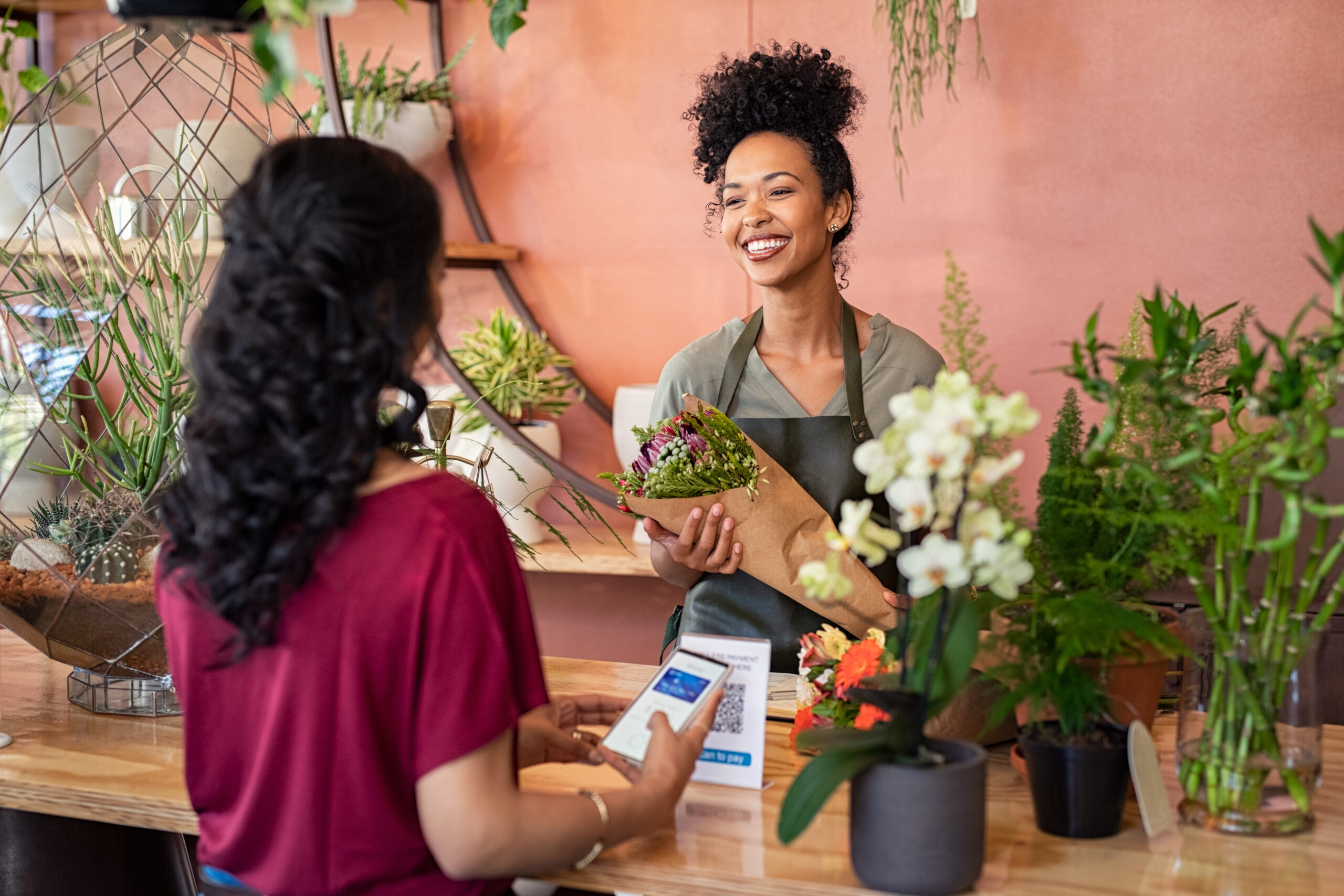 Customer paying with a digital wallet at a flower shop to minimise card surcharges