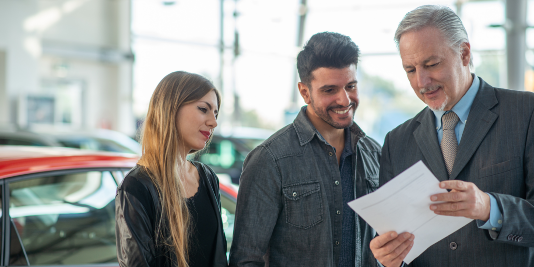 A dealer explaining used car warranties to buyer