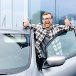 A happy man gesturing thumbs up buying used car in a car yard