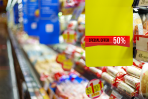 Supermarket shelf sign showing '50% OFF', promoting a special offer
