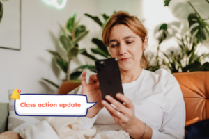 Class action member reading an update on her phone, staying updated with minimal effort.