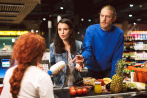 Shoppers making a complaint to the supermarket cashier about a milk in 'specials'