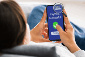 Woman holding phone with payment successful screen, ASIC logo shown under magnifying glass