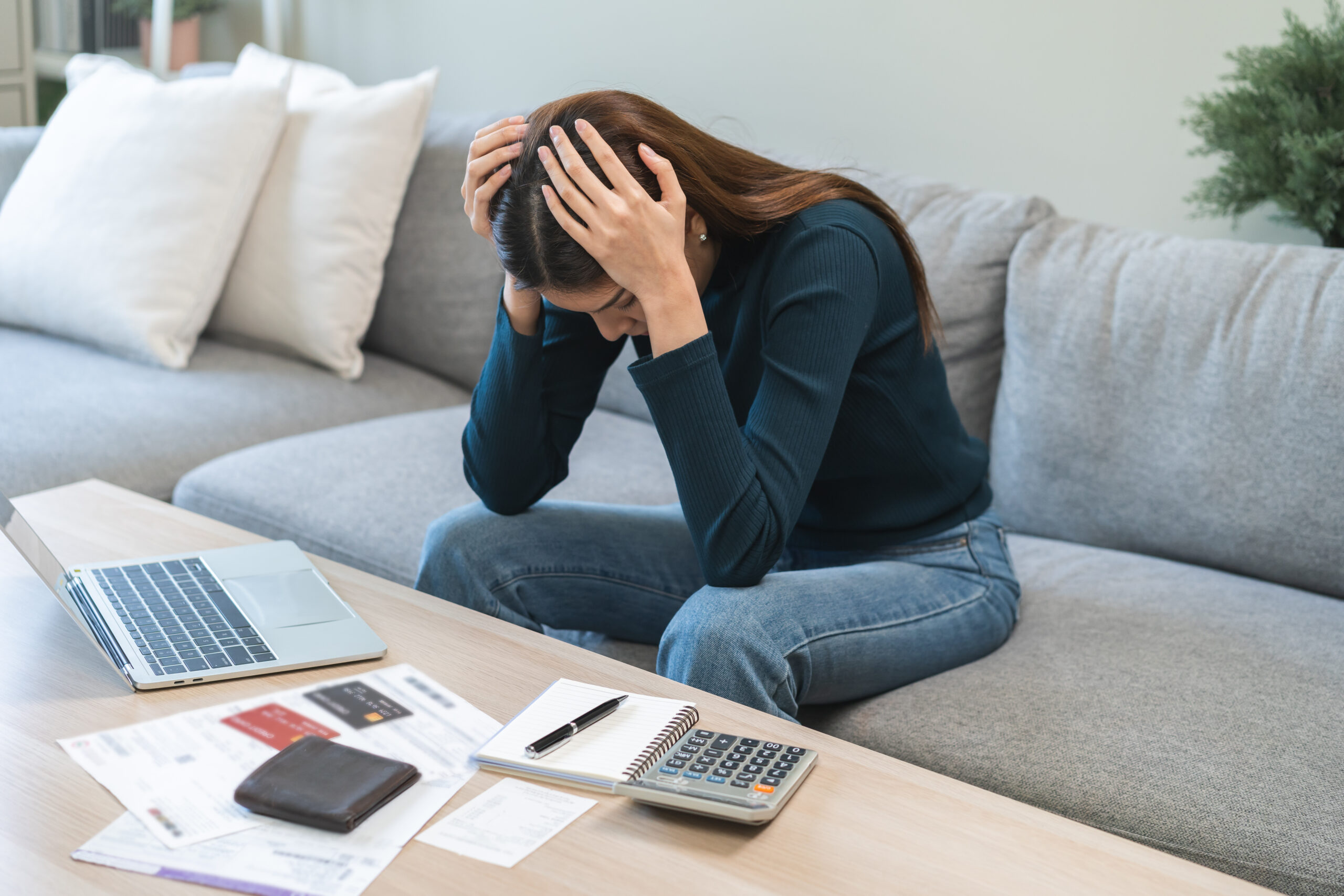 Woman sitting at home looking stressed while checking banking statements