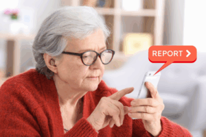 Elderly woman clicking the report button on her phone to flag a ghost store scam