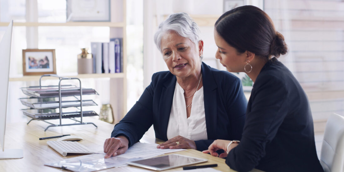 Older woman meeting with her lawyer to review documents and discuss her superannuation benefits for retirement
