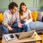 A couple reviewing bills and paperwork after their super insurance claim was denied, trying to make sense of what went wrong and what to do next