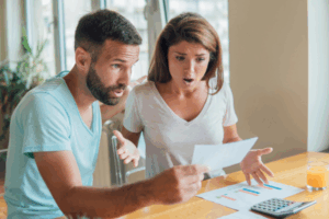 A couple checking their bank statement and shocked to see unexpected bank fees