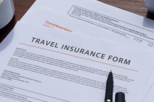 Stack of travel insurance claim forms and supporting documents on a desk, representing the travel insurance claims process
