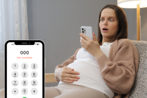 Pregnant woman looking worried at a smartphone displaying an unavailable Triple Zero call during a mobile network outage