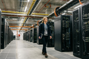 Professional Australian female engineer inspecting server racks inside a modern data centre during a site tour