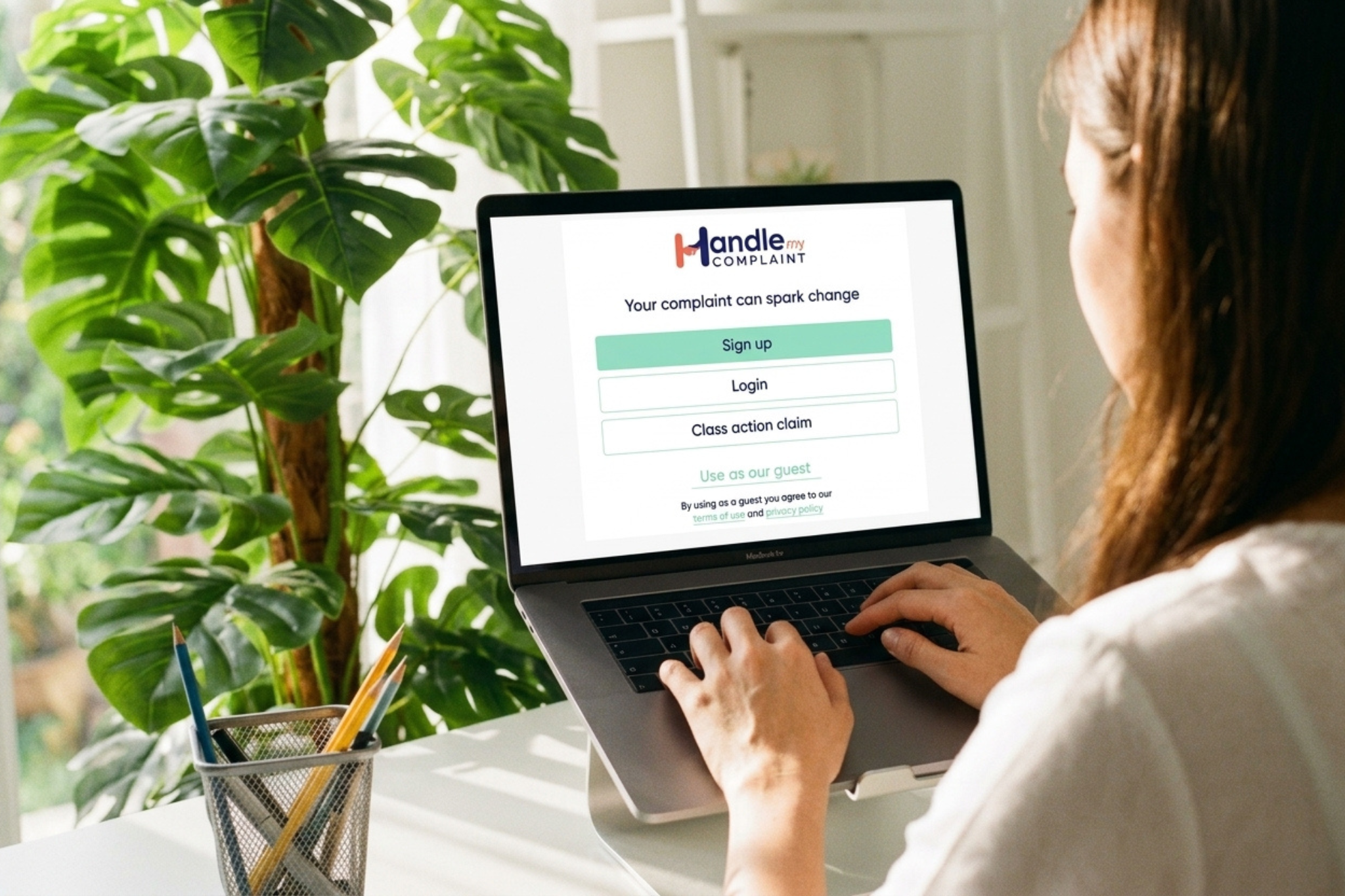 Woman making an electric vehicle complaint through Handle My Complaint (HMC) on a laptop